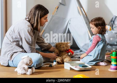 madre e figlia che giocano medico a casa Foto Stock