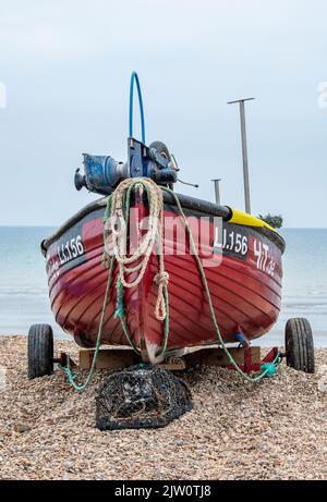 piccola barca da pesca da spiaggia a hastings sulla costa del kent su un tram pronto per il lancio dalla spiaggia, tradizionale spiaggia patrimonio lanciando pescatori Foto Stock