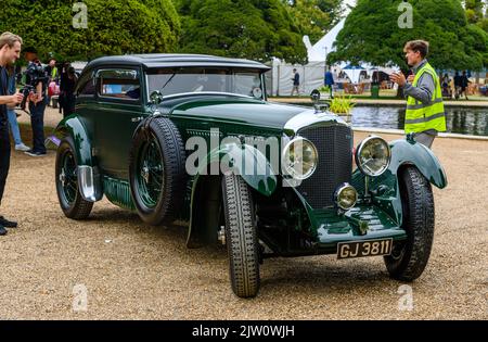 Auto che arrivano al Concours of Elegance 2022 che si tiene all'Hampton Court Palace Foto Stock