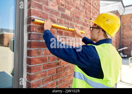 costruttore maschio con parete di misurazione di livello Foto Stock