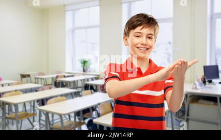 felice ragazzo sorridente allievo applaudente a scuola Foto Stock