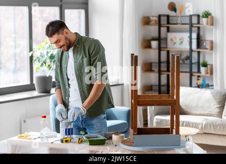 uomo apertura lattino con colore grigio a casa Foto Stock