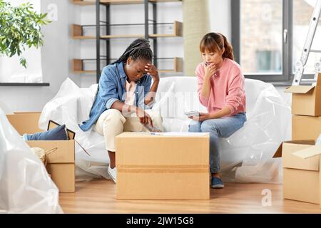 le donne che si spostano in una nuova casa e contano i soldi Foto Stock