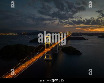 Vista aerea del lungo ponte sospeso con traffico leggero in prima serata Foto Stock