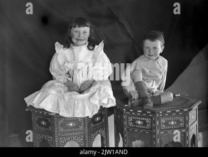 AJAXNETPHOTO. 1919-1920S (CIRCA). INDIA. FRONTIERA NORD-OCCIDENTALE. - HAPPY SNAP - DUE GIOVANI EDOARDIANI ERA POSA PER LA MACCHINA FOTOGRAFICA SEDUTA SOPRA MOBILI TRADIZIONALI IN LEGNO E INTARSIO. PHOTOGRAPHER:UNKNOWN © DIGITAL IMAGE COPYRIGHT AJAX VINTAGE PICTURE LIBRARY SOURCE: AJAX VINTAGE PICTURE LIBRARY COLLECTION REF:1920 3 2 Foto Stock