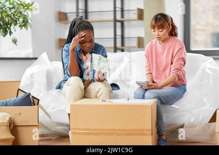 le donne che si spostano in una nuova casa e contano i soldi Foto Stock