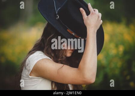 Ragazza teen che mancia il cappello del cowboy Foto Stock