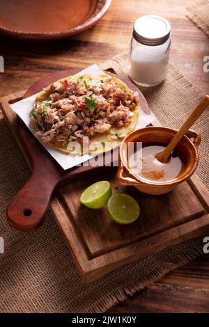 Taco de Carnitas. Tortilla di farina di mais con maiale fritto. Tradizionale antipasto messicano accompagnato comunemente da coriandolo, cipolla e salsa calda. Foto Stock