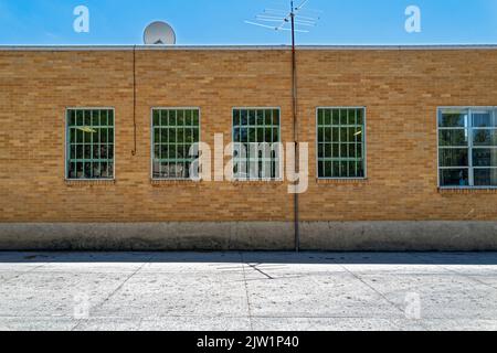 Le finestre sulla parete esterna di un edificio di uffici in mattoni Foto Stock