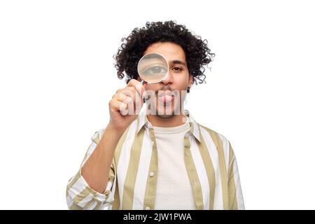 uomo felice che guarda attraverso la lente di ingrandimento Foto Stock