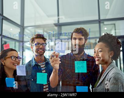 Theyre sempre motivandosi e ispirandosi a vicenda. I colleghi che brainstorming in un ufficio moderno. Foto Stock