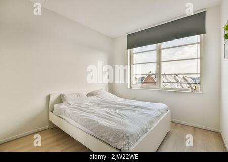 Comodo letto e armadio situato in camera da letto contemporanea a casa Foto Stock