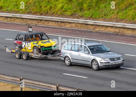 749 T-Bone DW Foto Stock car being trained on trailer by 2002 VW Volkswagen Silver PASSAT Sport TDi 1896cc 6 speed manual; Travelling on the M6 autostrada UK Foto Stock