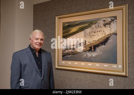 Il 617 Squadran Dambusters Association ambasciatore Bomber Command fund raising presidente Jim Dooley è in piedi con una fotografia firmata di una Lancaster Foto Stock