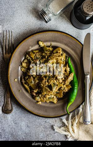 Tradizionale lobio estivo georgiano con fagioli francesi con uova ed erbe su sfondo di pietra con spazio copia Foto Stock