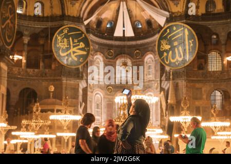 Viaggio a Istanbul concept foto. Donna che scatta foto di Hagia Sophia. Rumore incluso. Messa a fuoco selettiva. Istanbul Turchia - 8.12.2022 Foto Stock