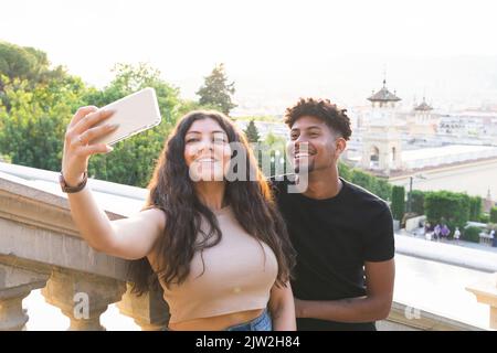 Giovane coppia sorridente che porta il selfie attraverso lo smartphone Foto Stock
