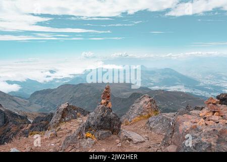 Vista panoramica della pila di pietre equilibranti luogo sulla roccia in altopiani sotto cielo nuvoloso blu Foto Stock
