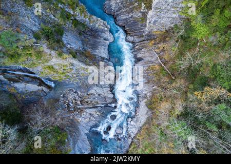 Vista aerea del fiume rapido con acqua blu che scorre attraverso la foresta mista il giorno d'autunno nelle Highlands Foto Stock