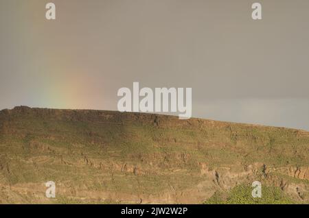 Arcobaleno su una cresta del cratere Tirajana. Santa Lucia de Tirajana. Gran Canaria. Isole Canarie. Spagna. Foto Stock