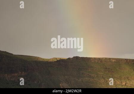 Arcobaleno su una cresta del cratere Tirajana. Santa Lucia de Tirajana. Gran Canaria. Isole Canarie. Spagna. Foto Stock