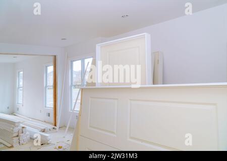 L'installazione di porte impilatrici bianche all'interno di una nuova casa è in fase di preparazione Foto Stock