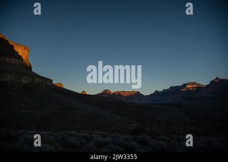 Il sole mattutino inizia ad evidenziare il Canyon Rim circostante dall'altopiano di Tonta nel Grand Canyon Foto Stock