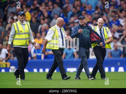 Gli steward rimuovono un fan invadente dal campo durante la partita della Premier League al Goodison Park, Liverpool. Data immagine: Sabato 3 settembre 2022. Foto Stock