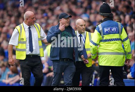 Gli steward rimuovono un fan invadente dal campo durante la partita della Premier League al Goodison Park, Liverpool. Data immagine: Sabato 3 settembre 2022. Foto Stock