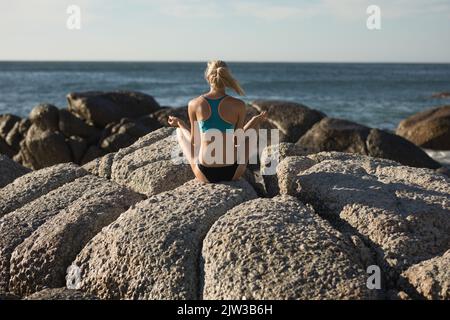 Medita sulla spiaggia una giocatrice di pallavolo femminile Foto Stock