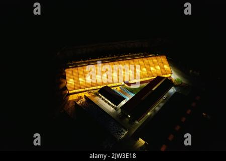 Farm mucca-casa aerea notte panorama di luminoso, vista aerea cowshed drone, luci attraverso il tetto luminoso nella notte scura, Repubblica Ceca, Europa Foto Stock