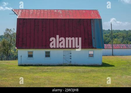 Foto di un fienile dal tetto rosso in un campo nella campagna della Virginia. Foto Stock