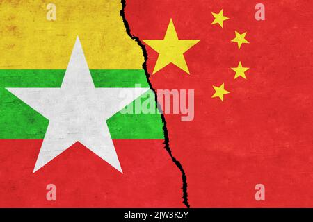 Cina e Myanmar dipinse bandiere su un muro con una crepa. Relazioni tra Cina e Myanmar. Myanmar e Cina bandiere insieme. Foto Stock