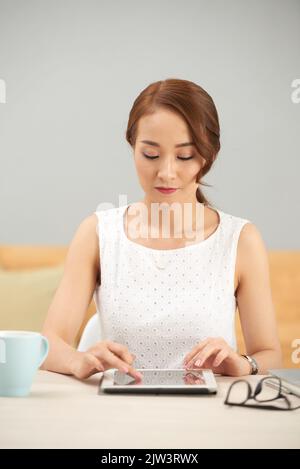 Imprenditore piuttosto giovane che utilizza l'applicazione sul computer tablet Foto Stock