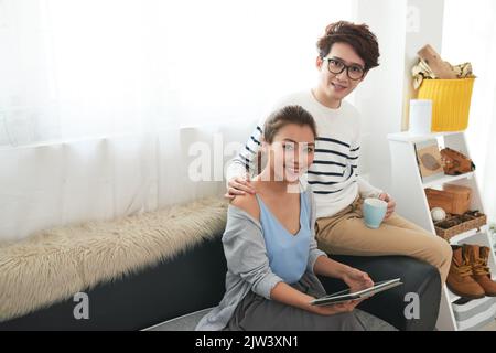 Ritratto di allegra giovane coppia asiatica che guarda qualcosa sul tablet insieme Foto Stock