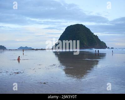Sembra che i turisti stiano godendo l'atmosfera in una destinazione turistica sulla spiaggia di Red Island a Banyuwangi Foto Stock