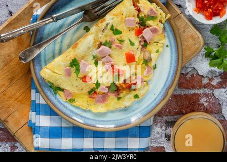 Frittata d'uovo con prosciutto, funghi e pomodori Foto Stock