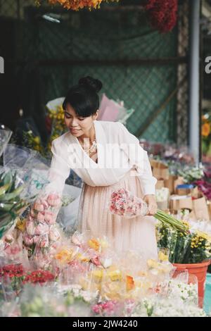 Bella fiorista scelta di fiori per fare bouquet Foto Stock