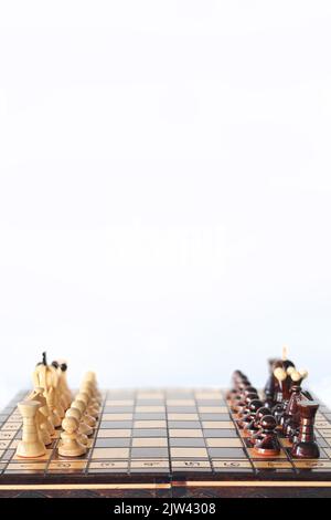Pezzi di scacchi in bianco e nero disposti sulla scacchiera prima inizio del gioco come due eserciti davanti a ciascuno altro Foto Stock