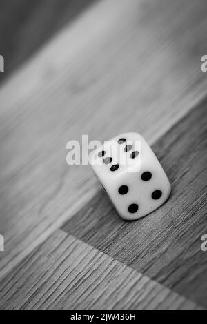 Dadi di gioco bianchi con il numero sei sul pavimento, immagine in bianco e nero Foto Stock