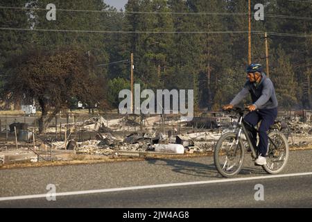 Weed, Stati Uniti. 23rd ago, 2022. Un locale residenti corse passato i resti di un piccolo quartiere che è stato distrutto dal fuoco di The.Mill a Weed, California Sabato, 3 settembre 2022. Foto di Peter DaSilva/UPI Credit: UPI/Alamy Live News Foto Stock