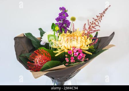 Mazzo di fiori colorati avvolti in carta, isolati su sfondo bianco Foto Stock