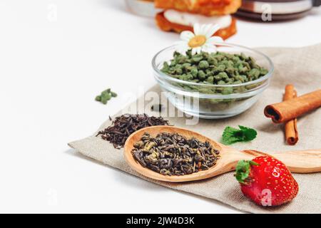 Raccolta fresca di foglie di tè su sfondo bianco, vista dall'alto, spazio copia. Assortimento o varietà di foglie di tè, tè pomeridiano concetto, dessert per il tè, caldo Foto Stock