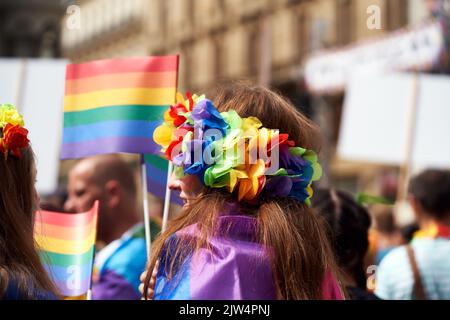 PRAGA, REPUBBLICA CECA - 13 AGOSTO 2022: Donna LGBT che indossa una corona arcobaleno a orgoglio gay, con bandiere colorate sullo sfondo Foto Stock