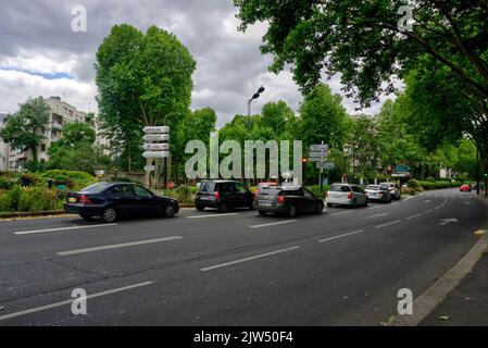 Parigi, Francia - 29 maggio 2022: Scena stradale vicino a Neuilly con coda di traffico a semafori, segnaletica stradale e alberi Foto Stock