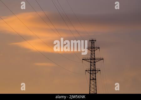 Elettricità e illuminazione. Supporti di linee elettriche ad alta tensione. Foto Stock