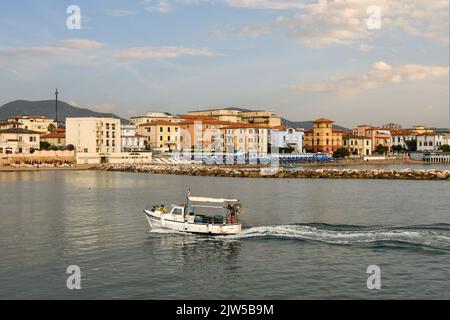 Una piccola barca da pesca che entra nel porto di San Vincenzo al tramonto, Livorno, Toscana, Italia Foto Stock