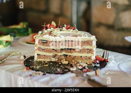 Primo piano della torta nuziale mangiata a metà Foto Stock