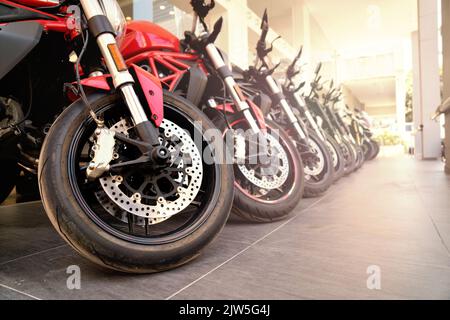 I motocicli in piedi in una fila sono venduti in un negozio sulla strada Foto Stock