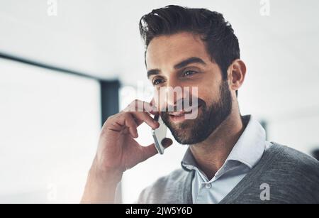 Salutando un'altra opportunità, un giovane uomo d'affari che parla sul cellulare in ufficio. Foto Stock